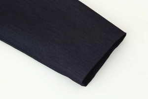 Gros plan sur les finitions de la manche en tissu bleu marine avec coutures précises
