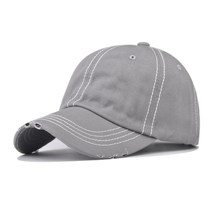 Close-up of vintage grey cotton baseball cap with white contrast stitching and distressed details