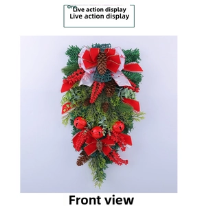 Detailed view of Christmas swag with pine cones, red berries, velvet bow and bells