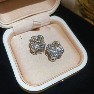 Macro shot of clover diamond earrings in silver on a luxury satin lined jewelry gift box