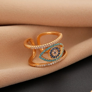 Macro shot of gold evil eye ring with blue and white zircons and a geometric open band