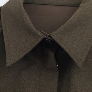 Detail shot of sharp collar and fine fabric texture on a dark brown mini dress