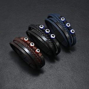 Detail of multi-layer braided leather bracelets with evil eye beads and magnetic clasp