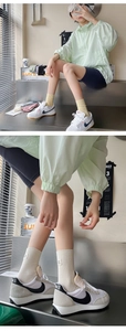 Détail de chaussettes mi-hautes en coton côtelé beige avec une étiquette carrée blanche