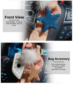 Detailed view of sparkling star keychains with faux fur balls in blue and champagne gold