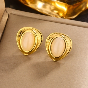 Détail de boucles d'oreilles vintage plaquées or 18K avec texture martelée et résine