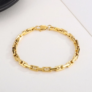 Macro shot of gold rectangular links and secure lobster clasp on the stylish bracelet