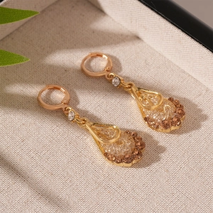 Detail of vintage gold-plated drop earrings featuring mesh set brown zircons in a jewelry tray