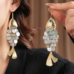 Vintage gold fish earrings with natural shell scales and blue evil eye detail