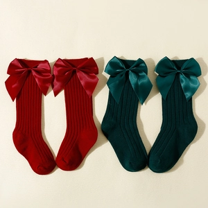 Spanish style baby high socks with large satin bows in festive red and dark green colors