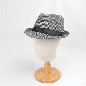 Detail of classic black and white houndstooth fedora hat with elegant satin ribbon