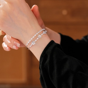 Gros plan de bracelets double couche en argent avec fleurs en zircon et cristaux
