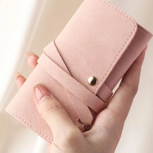 Close-up of pink microfiber jewelry roll bag with soft suede texture and elegant gold buckle