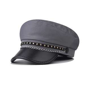 Stylish grey baker boy cap with gold stars and silver chain on plain background