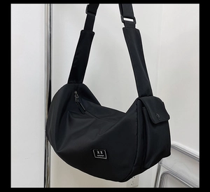 Detail of black nylon fitness bag with emoji patch, side pocket, and wide adjustable strap