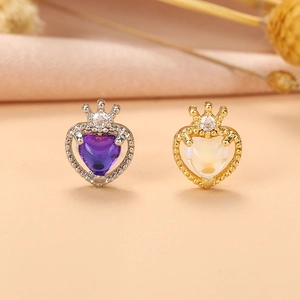 Détail de boucles d'oreilles couronne coeur avec zircons violets et blancs en or et argent