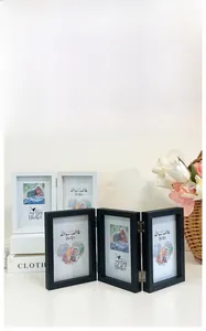 Close-up of folding wooden photo frames with silver metal hinges and baby photos