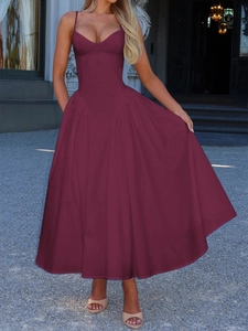 Elegant deep red long slip dress with a cinched waist shown in a classic porch setting