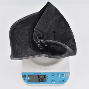 Detail view of a vintage cotton baseball cap weighing 76.2g on a digital scale