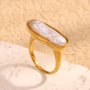 Detailed close-up of a 18K gold plated ring featuring a long baroque pearl on a stone base
