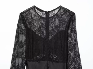 Detailed view of elegant black lace splicing on long-sleeved dress with satin texture