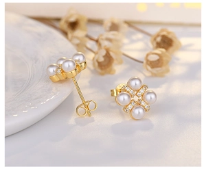 Macro shot of S925 silver needle floral pearl earrings with gold-plated setting
