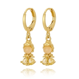 Detailed view of girl earrings with gold hooks and sparkling yellow pear-cut zircon