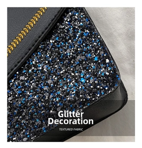 Close-up of black leather bag with blue and silver sequins and yellow embroidery