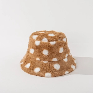 Dettaglio della texture del cappello bucket in peluche a pois marroni e bianchi in pelliccia