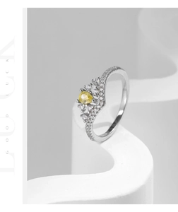 Macro shot of silver crown ring with a yellow pear-cut gemstone and pavé diamonds