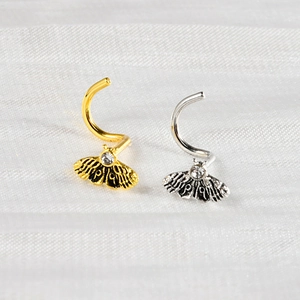 Vintage moth nose studs in gold and silver steel with crystal inlay on white fabric
