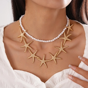 Close-up of a double-layer necklace featuring white pearls and golden starfish charms