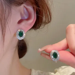 Elegant emerald green oval stud earrings with sparkling zircon halo in vintage silver finish