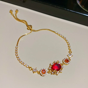 Detail of gold-plated flower bracelet with red gems and adjustable sliding closure