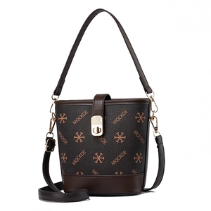 Brown monogram bucket bag with adjustable shoulder strap and leather trim in studio light
