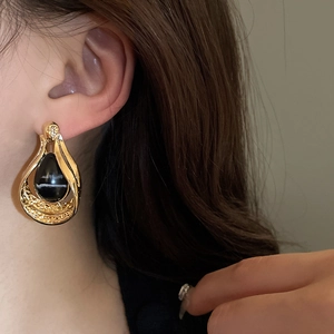 Vintage gold metal water-drop earrings with black agate stone inlay on model