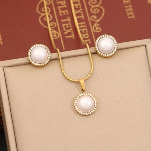 Macro shot of gold pearl necklace and earrings set with crystal stones in a jewelry box
