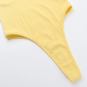 Close-up of bright yellow ribbed fabric texture and stitching on summer bodysuit