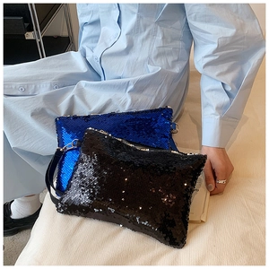 Detail of blue and black sequin clutches showcasing shimmering texture and hand straps
