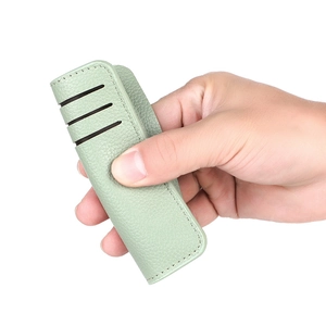 Slim light green PU leather card holder with textured surface and hollow grip design