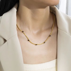 Close-up of gold titanium steel snake chain with five black rectangular zircon stones