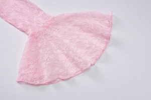 Close-up of pink lace sleeve detail with intricate floral patterns and sheer fabric