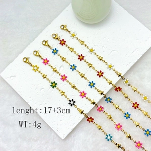 Macro view of 18k gold stainless steel daisy bracelet with colorful enamel flowers