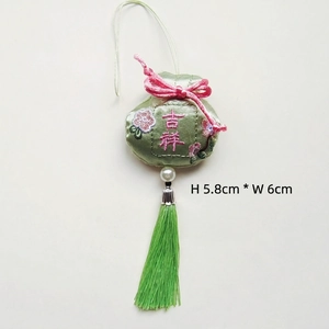 Detalle de una bolsa bordada verde con motivos florales y borlas de seda, talla 6x5,8cm