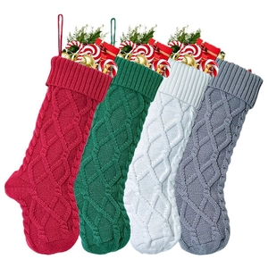 Set of four knitted Christmas stockings in red green white and grey with cable patterns