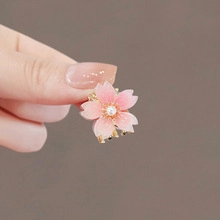 Detail of a pink gradient cherry blossom hair claw clip with pearl centers and gold metal