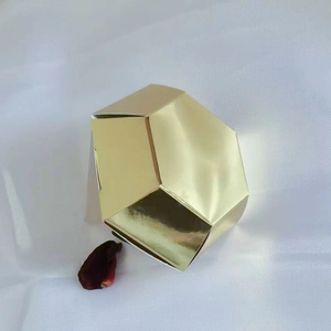 Golden diamond shaped geometric gift box on white fabric background for wedding favors