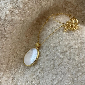 Elegant 925 sterling silver gold-plated necklace featuring an oval shell pendant on soft wool