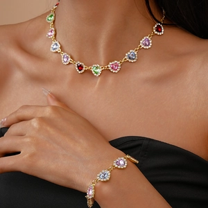 Détail d'un ensemble collier et bracelet en or avec pierres précieuses en cœur colorées