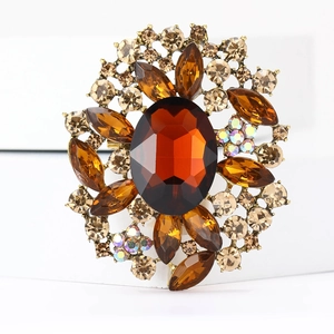 Nahaufnahme der Vintage-Bronzebrosche mit bernsteinfarbenem Glas und Strasssteinen
